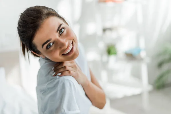 Beautiful smiling girl looking at camera in bedroom in the morning — Stock Photo