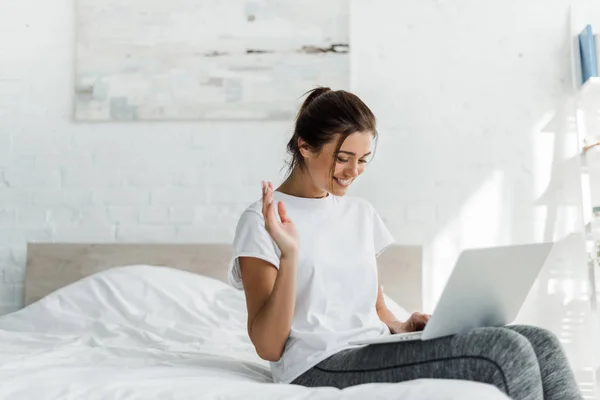 Schöne fröhliche Frau mit Laptop im Bett am Morgen — Stockfoto