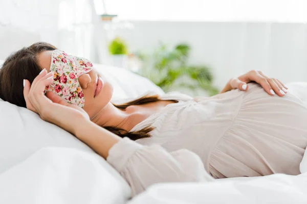 Pregnant woman lying in sleeping mask in bed — Stock Photo