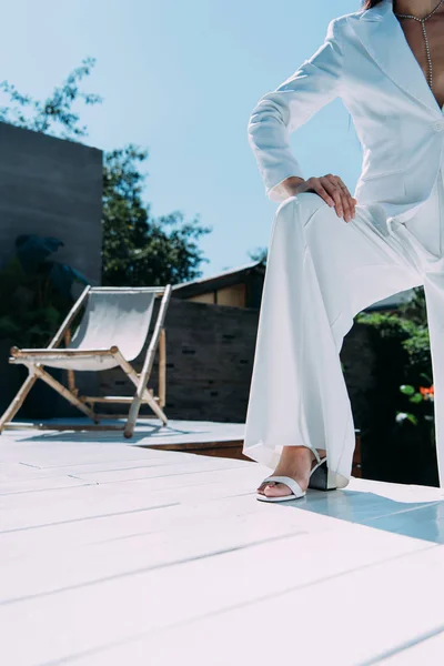 Cropped view of woman in white suit posing outside — Stock Photo