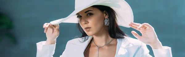 Panoramaaufnahme einer attraktiven Frau in weißem Anzug und Hut, die draußen posiert — Stockfoto