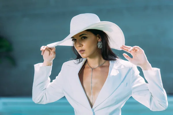 Attrayant femme en costume blanc et chapeau posant à l'extérieur — Photo de stock