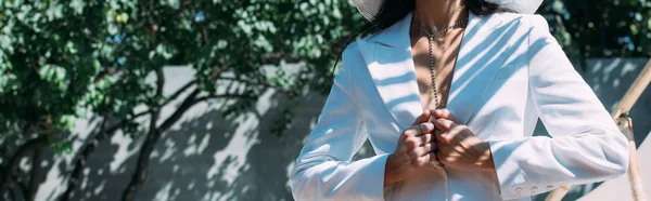 Tiro panorâmico de mulher em terno branco posando fora — Fotografia de Stock