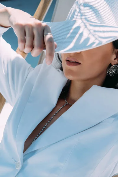 Mujer adulta en traje blanco y sombrero posando afuera - foto de stock