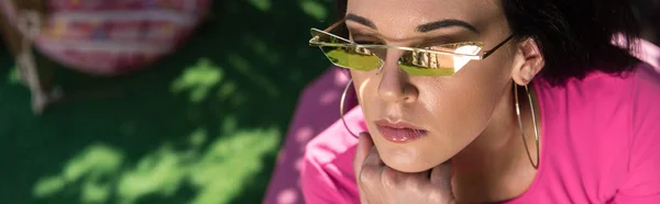 Panoramic shot of attractive woman in sunglasses looking away outside — Stock Photo