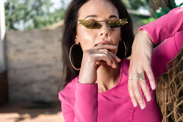 Attractive woman in dress and sunglasses posing and looking away outside — Stock Photo