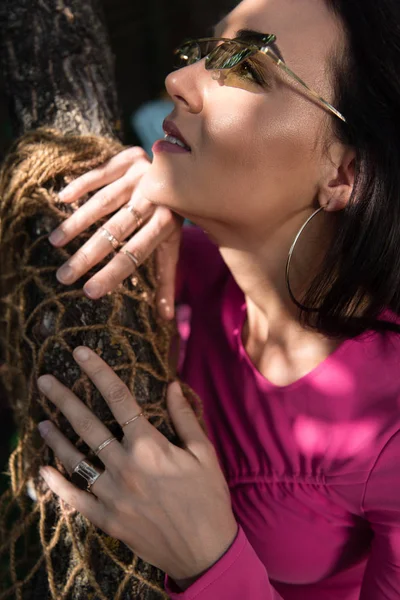 Donna attraente in abito e occhiali da sole in posa e guardando fuori — Foto stock