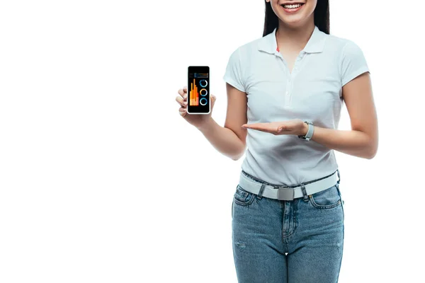 Recortado vista de feliz morena mujer asiática presentando smartphone con aplicación de negocios aislado en blanco - foto de stock