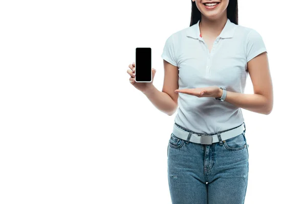 Recortado vista de feliz morena asiática mujer presentando smartphone con pantalla en blanco aislado en blanco - foto de stock