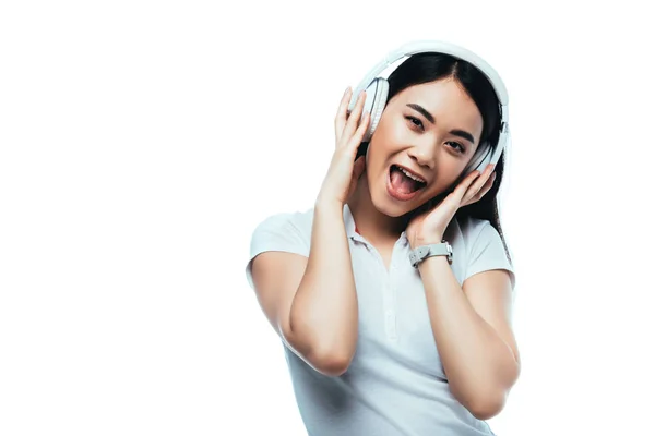 Excited attractive asian girl in headphones with open mouth isolated on white — Stock Photo