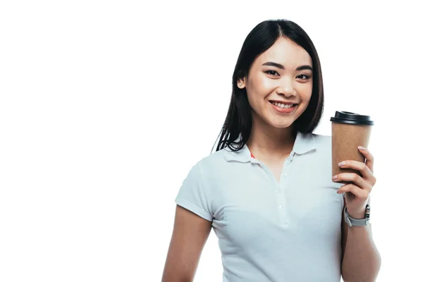 Улыбающаяся привлекательная азиатская девушка с бумажной чашкой, изолированной на белом — стоковое фото