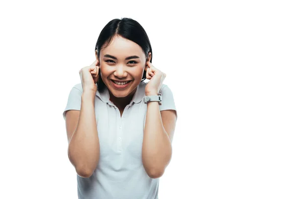Happy attractive asian girl putting fingers in ears isolated on white — Stock Photo