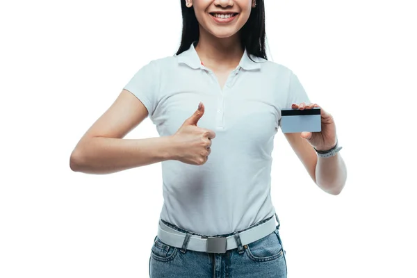 Vue recadrée de heureux attrayant asiatique fille tenant carte de crédit et montrant pouce vers le haut isolé sur blanc — Photo de stock