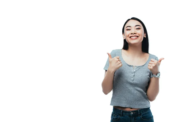 Щаслива приваблива азіатська дівчина показує великі пальці вгору ізольовано на білому — стокове фото