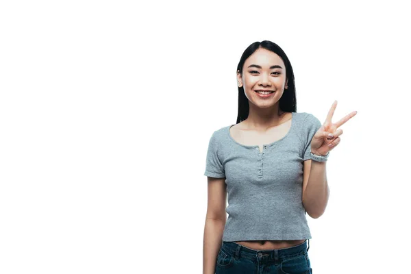 Счастливая азиатская девушка показывает знак мира изолированы на белом — стоковое фото