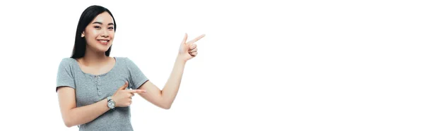 Glückliche asiatische Mädchen zeigt mit Fingern isoliert auf weiße, panoramische Aufnahme — Stockfoto