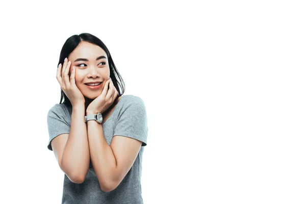 Щаслива азіатська дівчина торкається обличчя і дивиться ізольовано на білому — стокове фото