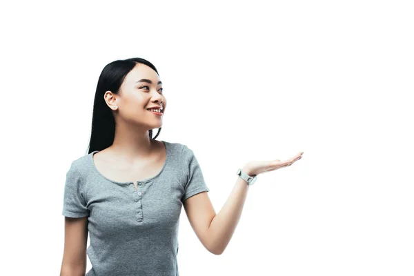 Smiling asian girl pointing with hand away isolated on white — Stock Photo
