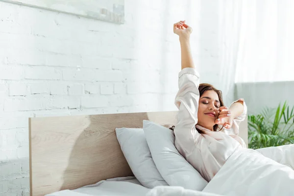 Attractive woman with closed eyes stretching herself at morning — Stock Photo