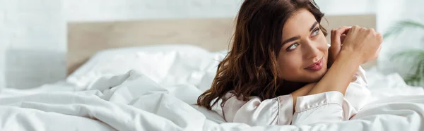 Panoramic shot attractive woman lying in bed at morning — Stock Photo