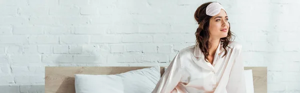 Panoramic shot of attractive woman in sleeping mask looking away at morning — Stock Photo