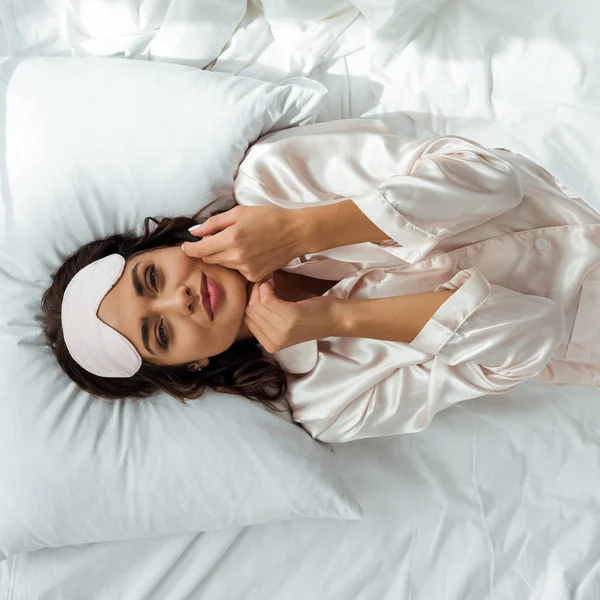 Vista dall'alto di attraente donna in maschera addormentata sdraiata a letto al mattino — Foto stock