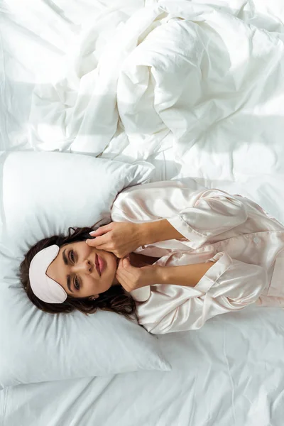 Vista superior da mulher atraente em máscara de dormir deitado na cama pela manhã — Fotografia de Stock