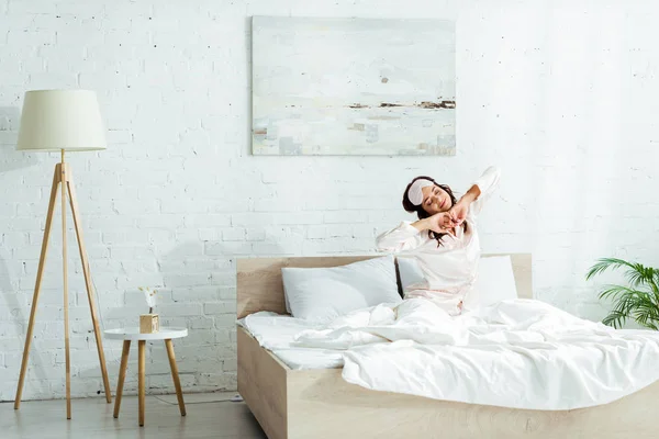 Attractive woman in sleeping mask stretching herself at morning — Stock Photo