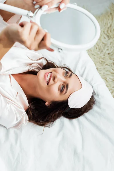 High angle view of attractive woman with sleeping mask looking at mirror at morning — Stock Photo