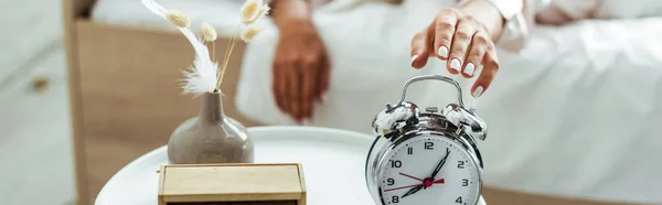 Panoramic shot of woman taking alarm clock at morning — Stock Photo