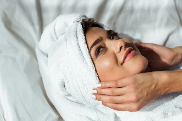 Mujer atractiva en toalla acostada en la cama por la mañana - foto de stock
