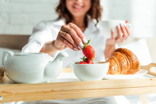 Vista cortada da mulher tomando café da manhã na cama de manhã — Fotografia de Stock