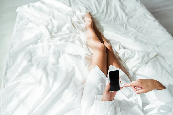 Cropped view of woman pointing with finger at smartphone with copy space at morning — Stock Photo