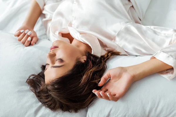 Alta vista del ángel de la atractiva mujer durmiendo en la cama por la mañana - foto de stock