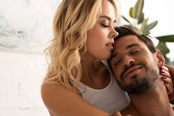 Feliz tierna pareja abrazando con los ojos cerrados por la mañana - foto de stock