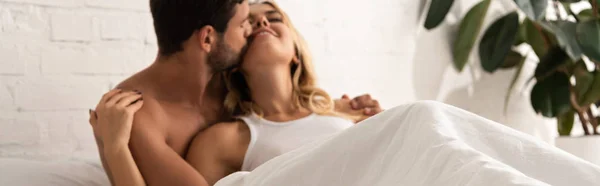 Homem macio beijando e abraçando namorada na cama pela manhã — Fotografia de Stock