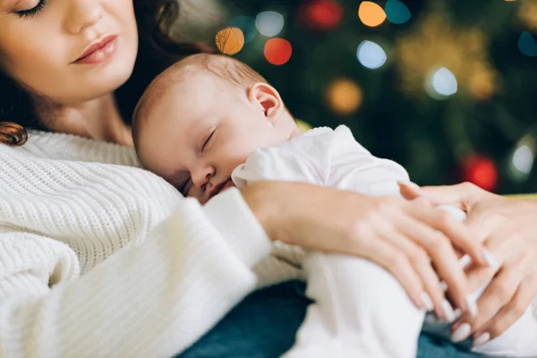 Cropped view of young mother holding sleeping baby — Stock Photo