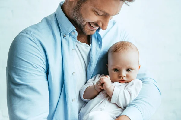 Щасливий батько посміхається, тримаючи чарівну маленьку дочку — стокове фото