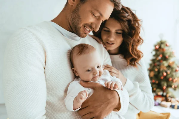 Happy mother standing near husband holding cute little daughter — Stock Photo