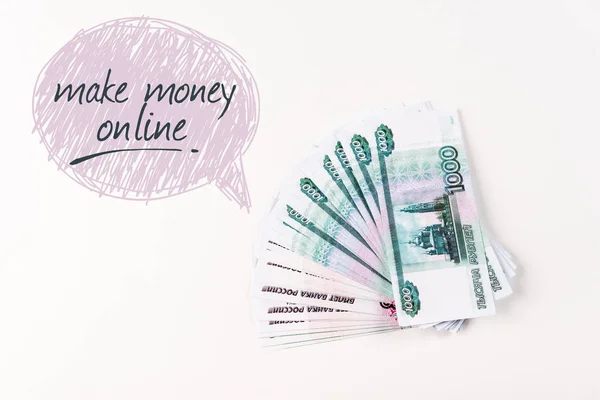 Top view of russian money on white background with make money online lettering in speech bubble — Stock Photo