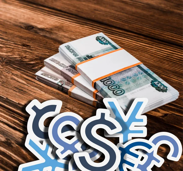 Russian banknotes on wooden table with currency icons illustration — Stock Photo