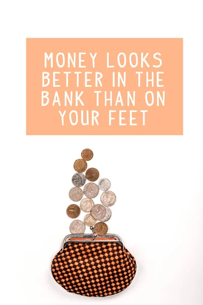 Top view of plaid purse near scattered coins on white background with money looks better in the bank than on your feet illustration — Stock Photo