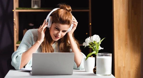 Woman in headphones watching webinar on laptop in cafe — Stock Photo