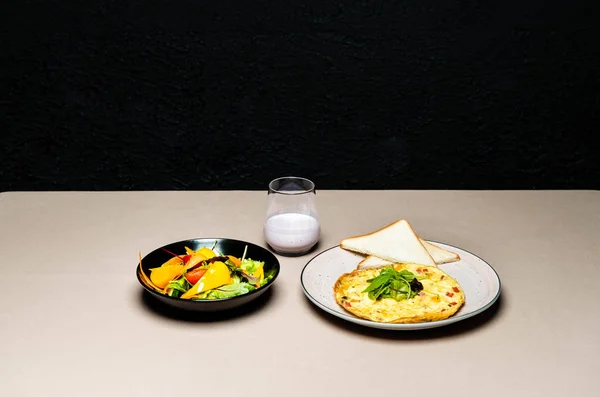 Savoureuse salade, omelette, toasts et yaourt en verre sur la table — Photo de stock