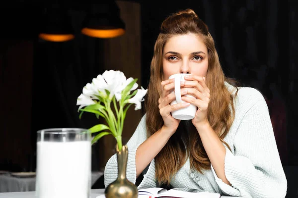 Beautiful pensive woman drinking coffee in cafe — Stock Photo