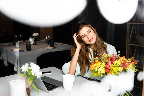 Attraente donna rossa felice con mazzo di fiori autunnali in caffè con dispositivi digitali — Foto stock