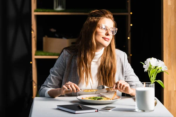 Belle femme petit déjeuner dans un café avec bloc-notes et smartphone — Photo de stock