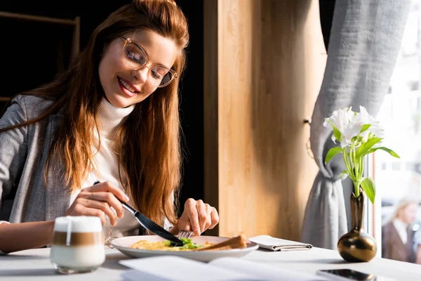 Fröhliche attraktive Frau frühstückt im Café — Stockfoto