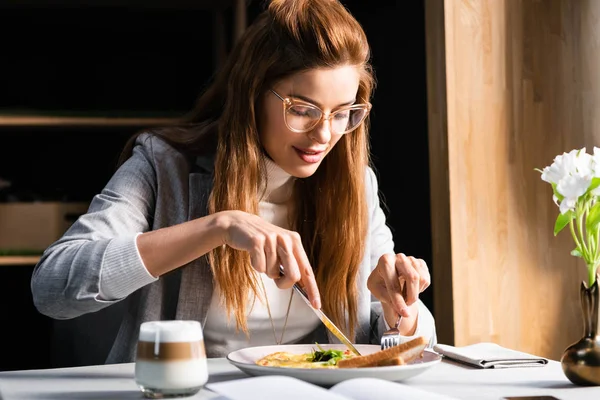 Donna felice mangiare frittata per la prima colazione nel caffè — Foto stock