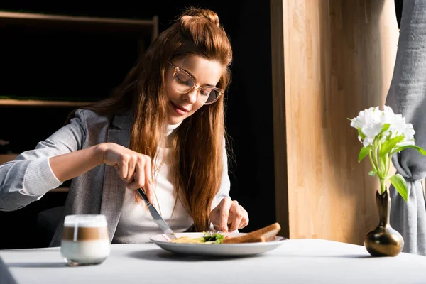 Bella donna rossa che fa colazione con caffè in caffè con fiori — Foto stock